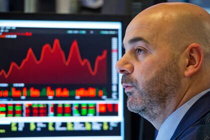 Credit Suisse bei Aktien leicht untergewichtet Händler an der Wall Street, im Hintergrund Kursgrafiken.