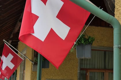 Das ändert sich im August in der Schweiz Schweizerfahnen an der Schifflände in Vitznau LU am Vierwaldstättersee.