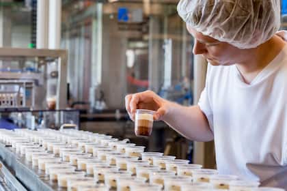 Warum die Aktie von Emmi nach dem 19-Monate-Hoch weiter steigen kann Ein Mitarbeiter von Emmi in der Produktion.