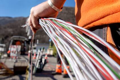 Börsen-Ticker : Schweizer Aktienmarkt schliesst im Minus - 12 von 20 SMI-Titel mit Verlusten - Swisscom als Tagesverlierer - Finanzwerte gefragt - Polypeptide und Newron mit Kurssprung - Ölpreis über 100 Dollar Ein Arbeiter montiert Glasfaserkabel der Swisscom für den Internetansschluss von Privathaushalten.