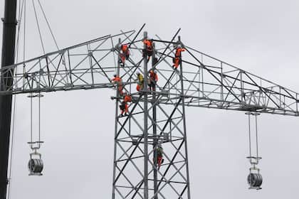Investieren in die Zukunft: Strom-Aktien aus der Schweiz, Europa und den USA Industriekletterer arbeiten an einem neuen Strommast in Deutschland.