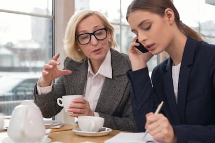 Mutlose Alte bremsen mutige Junge aus Eine jüngere und eine ältere Frau im Gespräch bei der Arbeit (2018).