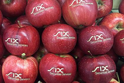Handelsgeschehen bei Aktien schläft ein Äpfel mit dem SIX-Logo.