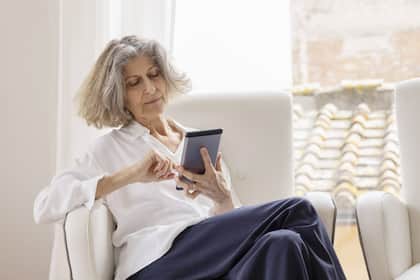 Pensionskasse: Diese Kriterien geben Auskunft darüber, ob freiwillige Einkäufe sinnvoll sind oder nicht Frau sitzt mit Taschenrechner auf dem Sofa - Ein Teil der 13. AHV-Rente fliesst wieder an der Staat zurück. Ob man diesen Anteil als irrelevant, angemessen oder als zu viel taxiert, ist ausschlaggebend