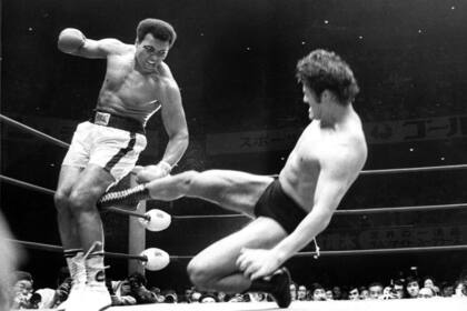 Leerverkäufer werfen bei Aktien entnervt das Handtuch Muhammad Ali im Ring (26. Juni 1976, Tokio, Japan).