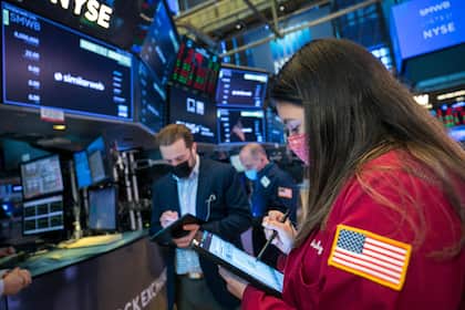 Jetzt erst recht: Profis gehen bei Aktien in Deckung Händlerin mit Schutzmaske auf dem Börsenparkett der New Yorker Stock Exchange.