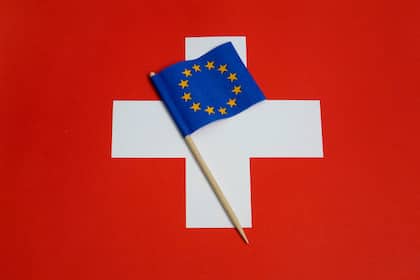 Über eine halbe Million hätten neu ein Recht auf Daueraufenthalt EU-Fähnchen auf einer Schweizer Fahne (2018).