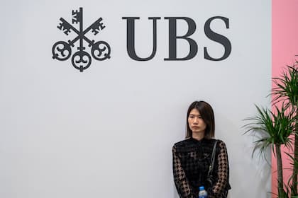 Börsen-Ticker: SMI schliesst im Plus und setzt neue Intraday-Rekordmarke - UBS und Holcim beenden Handel auf Tagestief - Kühne+Nagel, Givaudan und Straumann an der Spitze UBS-Logo mit Besucherin an der "Art Basel Hong Kong" .