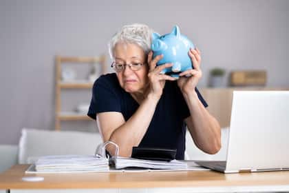 Gestiegene Zinsen beflügeln Gewinne der Schweizer Banken - Erträge für Sparer bleiben mager Eine Frau betrachtet besorgt ihre Finanzen.