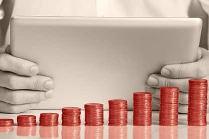 US-Investoren legen bei ihren Aktienverkäufen eine Schippe drauf Business Hand Tablet Münzen gestapelt Sparplan