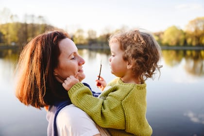 Tipps für eine gute Vorsorgeplanung Eine Mutter trägt ihre Tochter im Park.