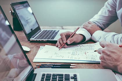 Warum KI-Nutzer mehr arbeiten als vorher Über einem Papier brüten.