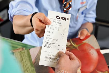 Coop senkt 1000 Preise - aber über 2000 Produkte wurden teurer Eine Coop-Verkäuferin reicht der Kunden den Kassenzettel.