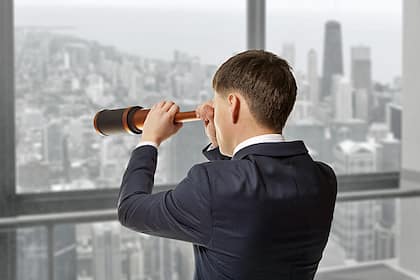 Credit Suisse: Noch kein klares Verkaufssignal für Aktien Geschäftsmann schaut durch ein Fernrohr.