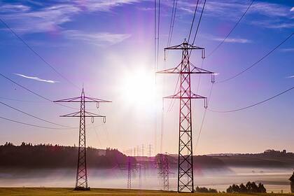 Stromaktien: Sind sie für Anleger ein gewinnbringender Kauf? Strommasten in der Morgensonne.