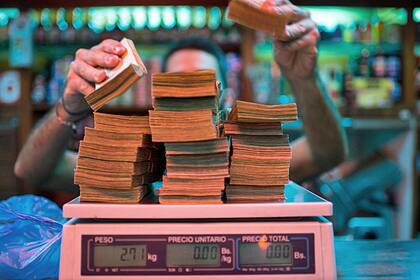 Inflation: Bank warnt vor Teuerungsschub A manager weighs banknotes on a scale at a bakery in Caracas, Venezuela, on Thursday, Oct. 13, 2016.