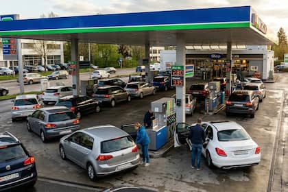 Fünf potenzielle Krisenprofiteure im aktuellen Marktumfeld Weitwinkelaufnahme einer modernen Tankstelle bei bewölktem Himmel. Lange Autoschlangen stehen an den Zapfsäulen an. Die digitalen Preisanzeigen zeigen deutlich 2.80 für Bleifrei und 3.35 für Diesel.