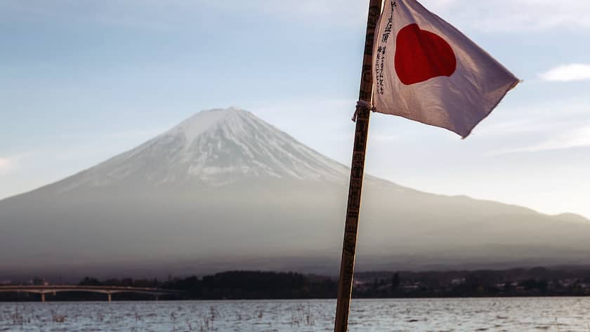 Die Nationalflagge Japans mit dem Fuji-Berg im Hintergrund.
