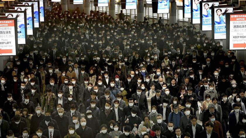 Pendler tragen Schutzmasken am Bahnhof Shinagawa in Tokio Anfang März 2020.