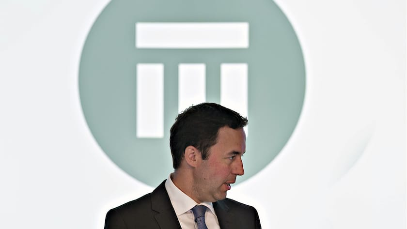 Swiss-Re-CEO Christian Mumenthaler, im Hintergrund das Logo des Rückversicherungskonzerns.