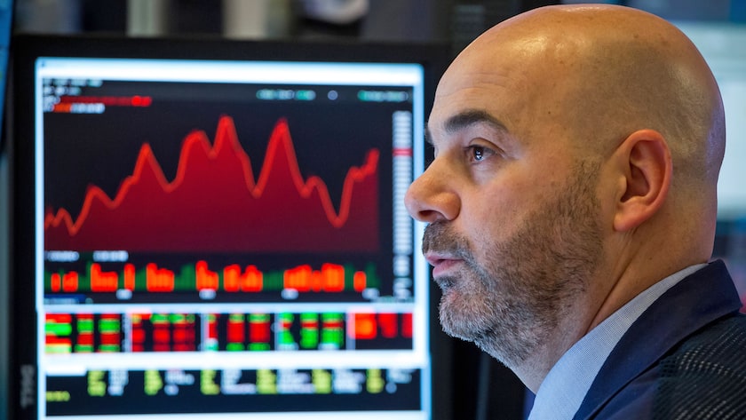 Händler an der Wall Street, im Hintergrund Kursgrafiken.