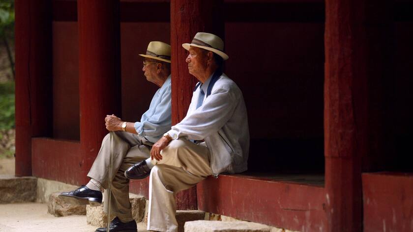 Zwei Rentner sitzen an einem Schrein in Soeul.