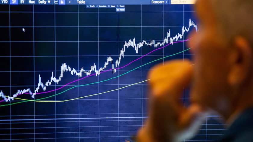 Ein Händler an der New York Stock Exchange (NYSE) vor einer Kurstafel.