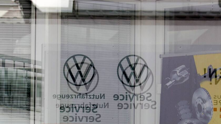 Symbolbild VW in der Krise: Spiegelverkehrte VW-Logos hinter einer Fensterscheibe (September 2024).