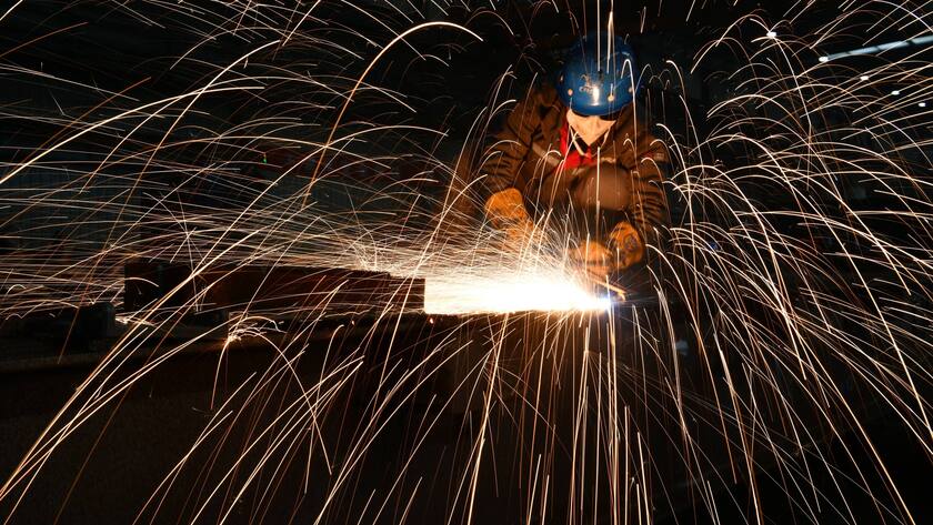 Ein Angestellter bearbeitet eine Radachse in der Stadt Shijiazhuang in der chinesischen Provinz Hebei.