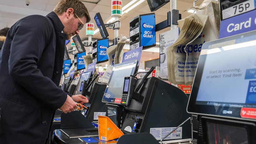 Ein Konsument an einer Kasse der Supermarkt-Kette Tesco in London.