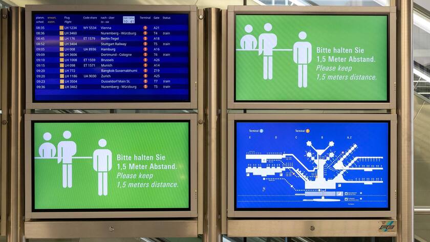 Grüne Hinweistafeln am Frankfurter Flughafen erinnern die Passagiere an die Einhaltung des Sicherheitsabstands.