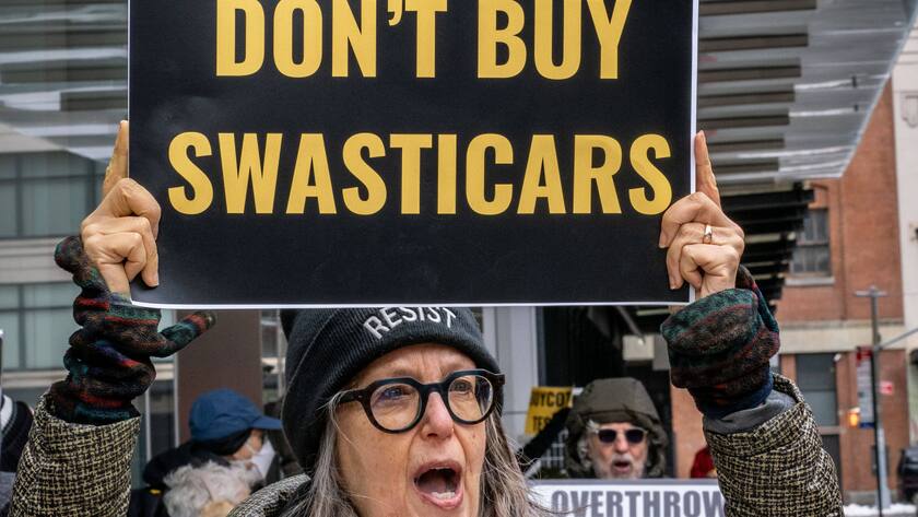 Eine Frau protestiert am 9. Februar 2025 vor einem Tesla-Showroom in New York, USA.