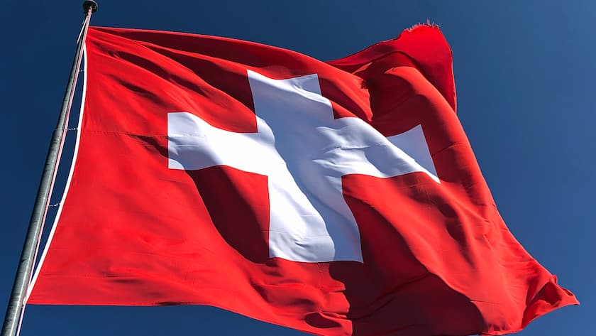 Schweizer Flagge flattert straff im Bergwind.