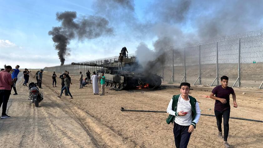 Hamas-Anhänger vor einem zerstörten israelischen Panzer (2023).