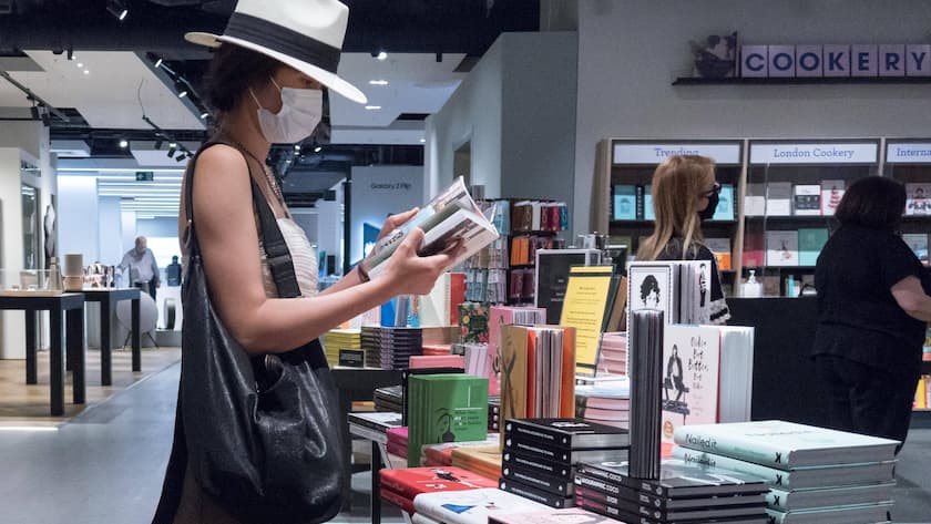 Maskenpflicht in Läden: Frau mit Hut und Gesichtsschutz in einem Londoner Warenhaus.