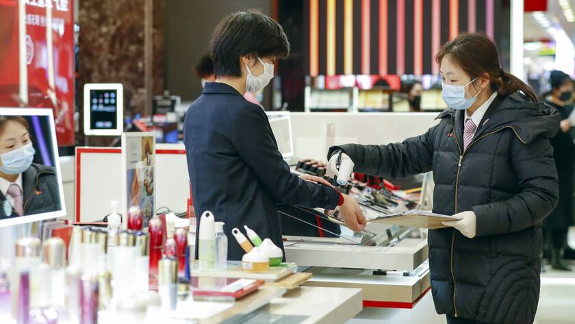 Shopping in China: Eine Verkäuferin in einer Mall in Wuhan lässt sich die Temperatur messen.