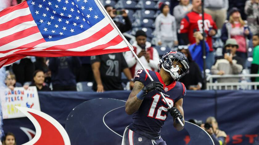 Spieler des American-Football-Teams Washington Commanders mit einer US-Flagge in Houston, Texas.