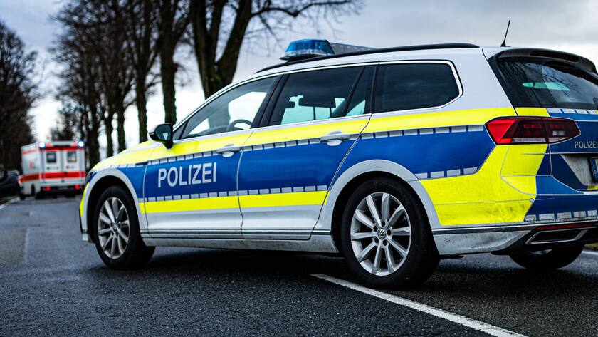 Ein Streifenwagen, der Polizei steht mit Blaulicht und dem Schriftzug als Strassensperre auf einer Landstrasse.