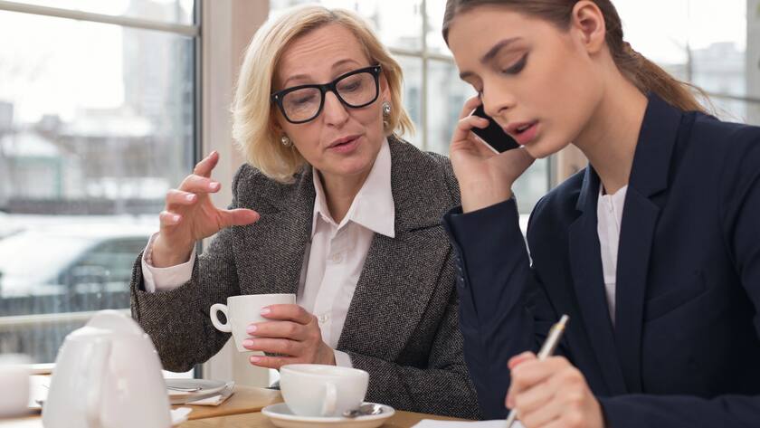 Eine jüngere und eine ältere Frau im Gespräch bei der Arbeit (2018).
