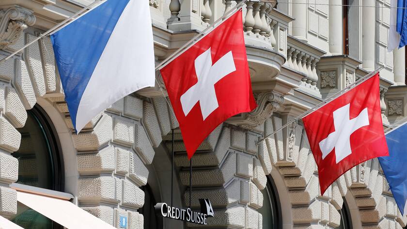 Sitz der Credit Suisse mit Fahnen der Schweiz und Zürichs.