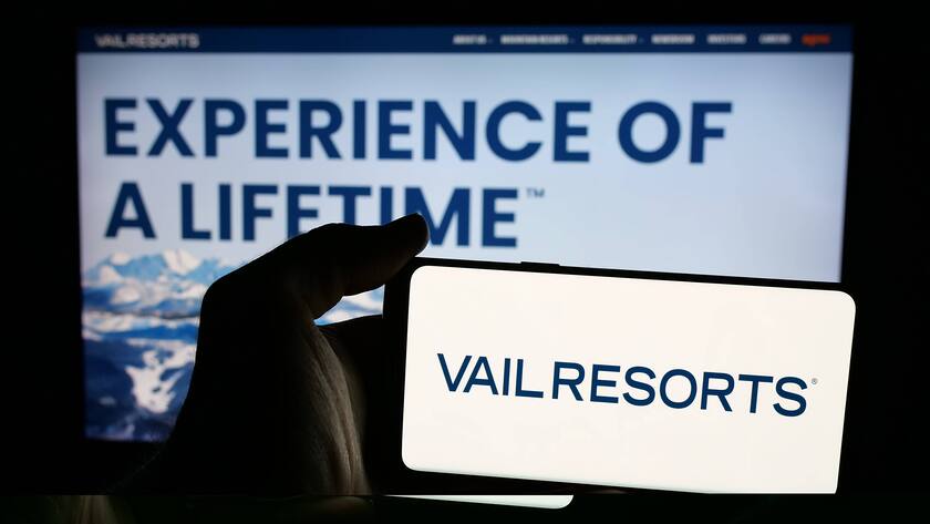 Eine Person hält ein Mobiltelefon mit dem Logo des US-amerikanischen Bergsportunternehmens Vail Resorts Inc. vor der Webseite.