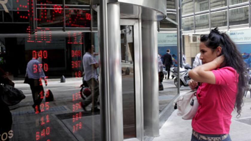 A woman looks at currency exchange rates in Buenos Aires, Argentina, on Wednesday, Feb. 12, 2014.
