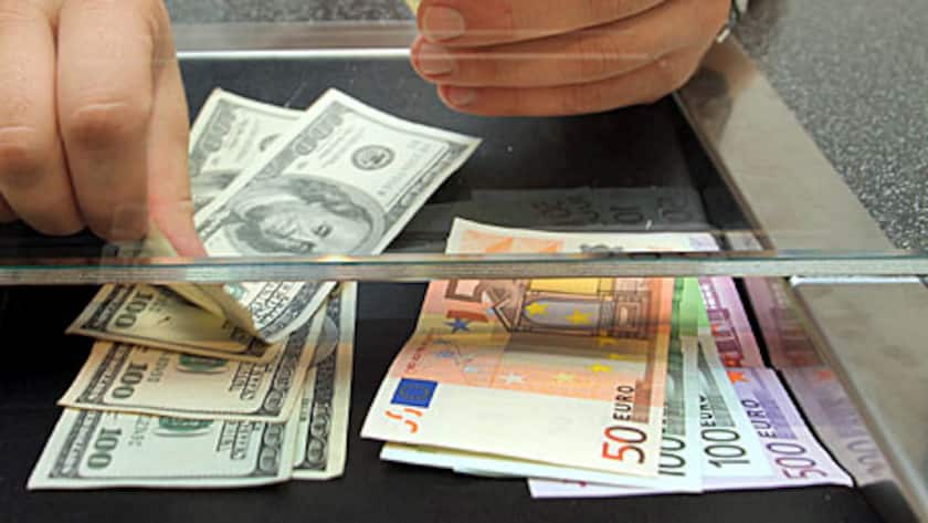 An employee counts out euro and dollar bills at a currency exchange office in Frankfurt, Germany, on Monday, Aug. 9, 2010.