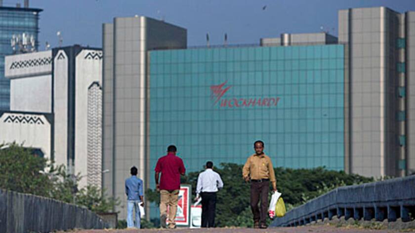 Commuters walk in front of the Wockhardt Ltd. headquarters in the Bandra Kurla Complex in Mumbai, India, on Tuesday, Nov. 6, 2012.