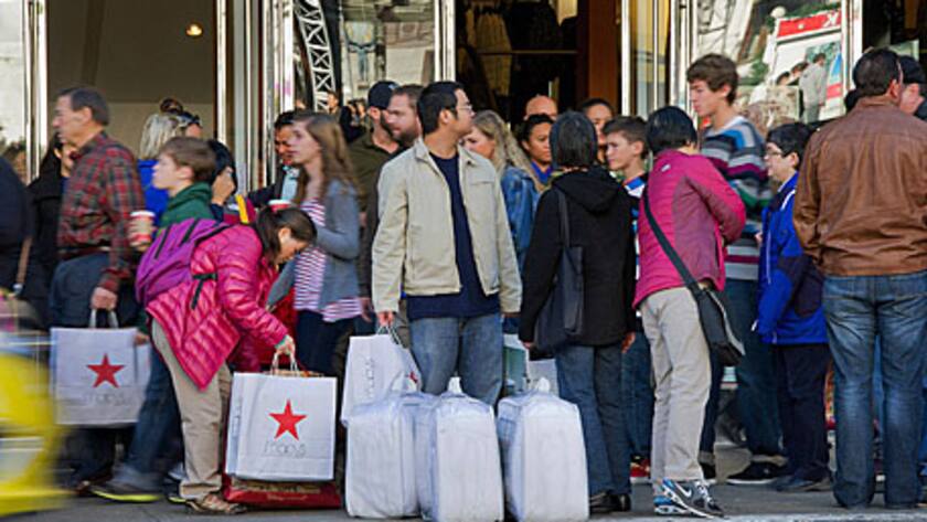 A customer holds shopping bags outside of a Macy's Inc. store in San Francisco, California, U.S., on Friday, Nov. 23, 2012.