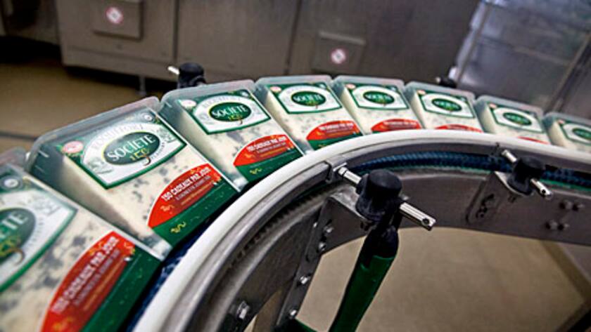 Packets of Roquefort Societe 150years cheese pass along the packaging line at the Lebrou-Roquefort plant, part of Groupe Lactalis SA, in Roquefort, France, on Wednesday, May 29, 2013.