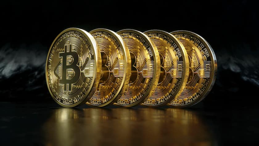 Eine Reihe glänzender neuer goldener Bitcoins.