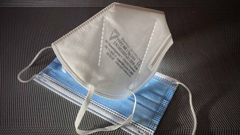 FFP2-Masken (weiss) sind dichter als herkömmliche Mund-Nase-Masken (blau).