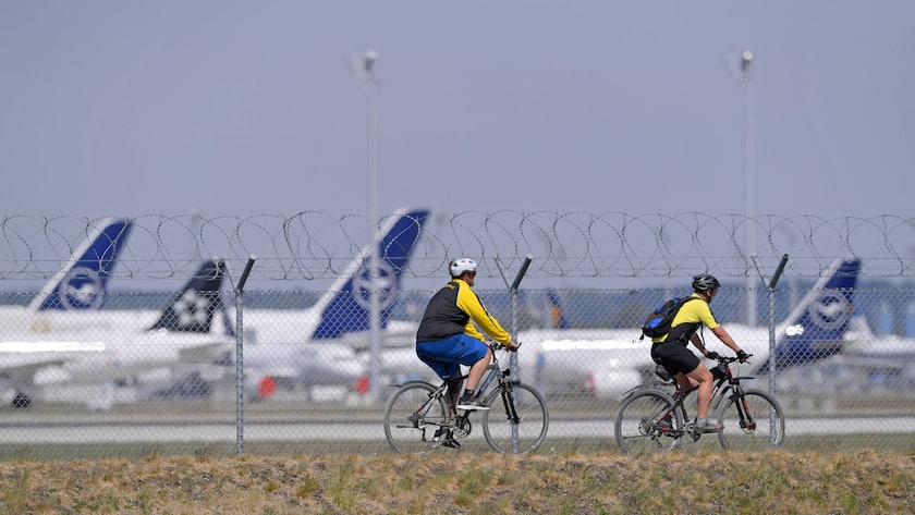 Velofahrer am Flughafen München, im Hintergrund parkierte Lufthansa-Maschinen.
