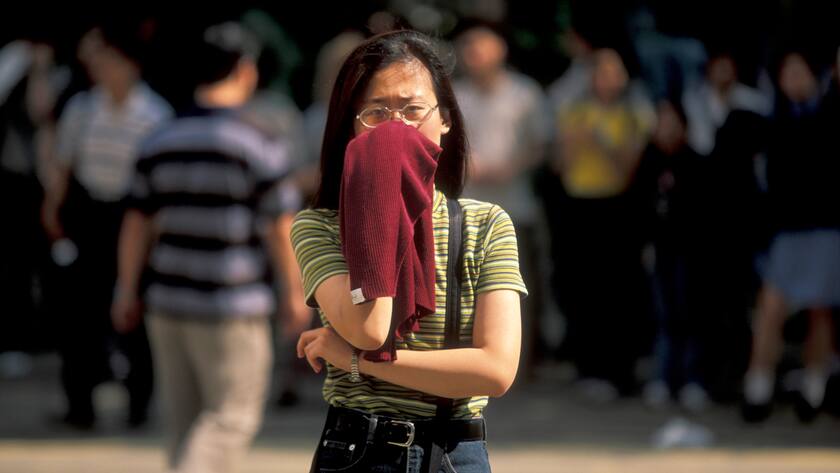 Eine Frau in Hongkong schützt sich mit einem Tuch vor der hohen Luftverschmutzung.